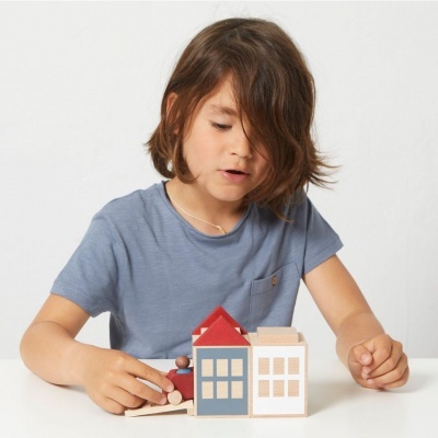 Criança a brincar com brinquedos de madeira coloridos em mesa branca