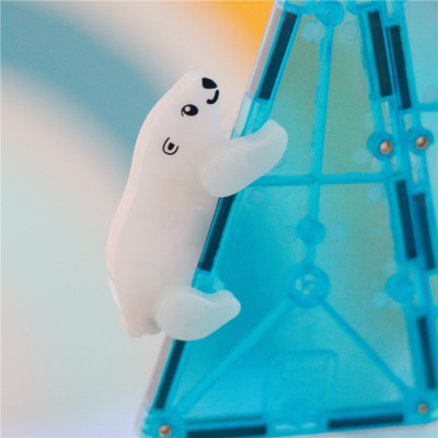 Figura branca de urso polar agarrada a estrutura plástica azul