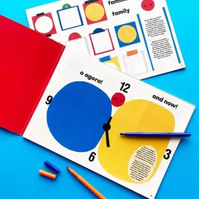 Livro infantil colorido aberto com relógio estilizado e lápis coloridos ao lado