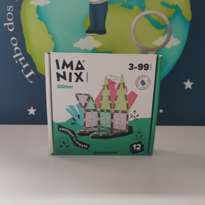 Caixa do jogo IMANIX Glitter com peças triangulares de plástico verde translúcido e glitter, com fundo azul estrelado.