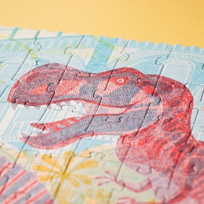 Cabeça de dinossauro vermelho em puzzle de papel colorido