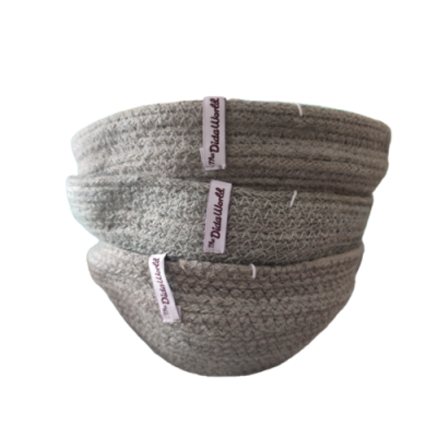 Três cestos redondos de tecido cinzento com etiqueta The Dirty Work