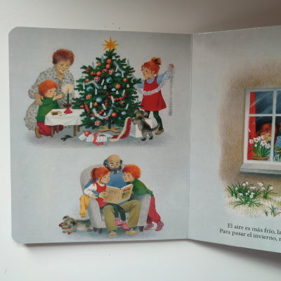 Livro infantil aberto com ilustrações natalinas e texto em espanhol
