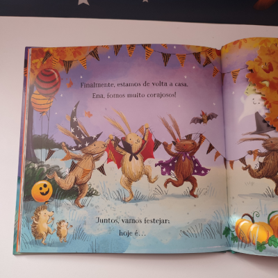 Livro infantil aberto com coelhos fantasiados e decoração de Halloween