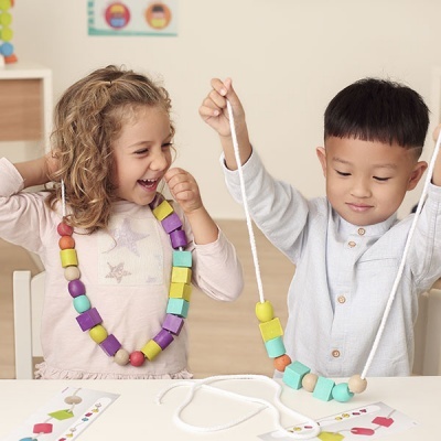 Crianças a brincar com colares coloridos de madeira