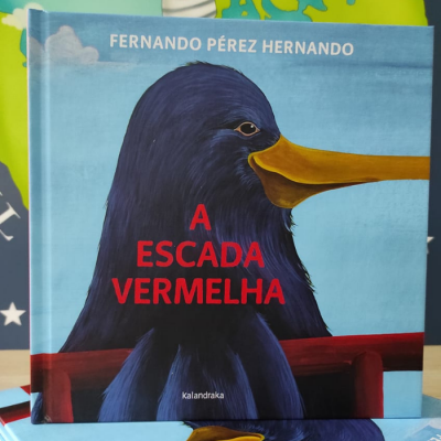 Capa de livro com ilustração de um pássaro azul de bico amarelo e texto 'A ESCADA VERMELHA'