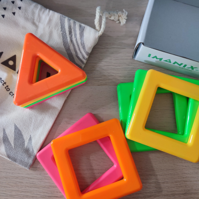 Peças de plástico coloridas em formas geométricas com saco de pano e caixa