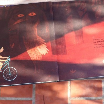 Livro aberto com ilustração de raposa e cão num bicicleta, texto em português