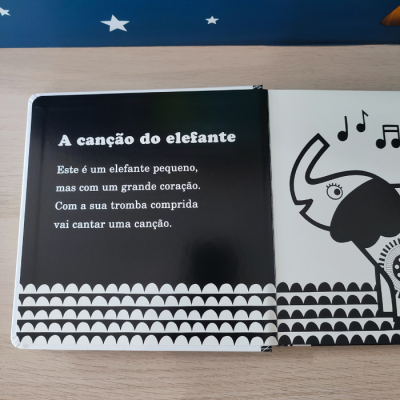 Página de livro infantil com texto e ilustração de elefante preto e branco