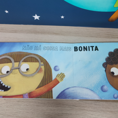 Página de livro infantil com texto e ilustrações de crianças sobre fundo azul