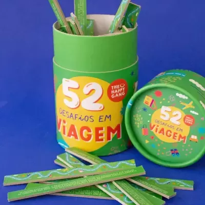 Embalagem verde cilíndrica com palitos de desafio para viagem e tampa azul