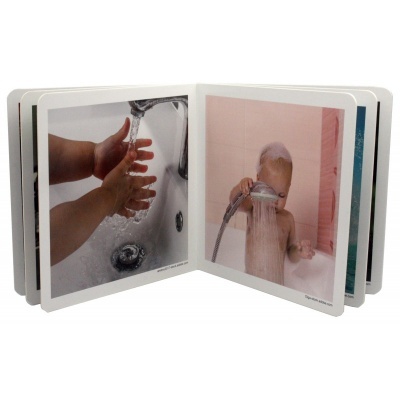 Livro infantil aberto mostrando imagens de criança a lavar as mãos e tomar banho.