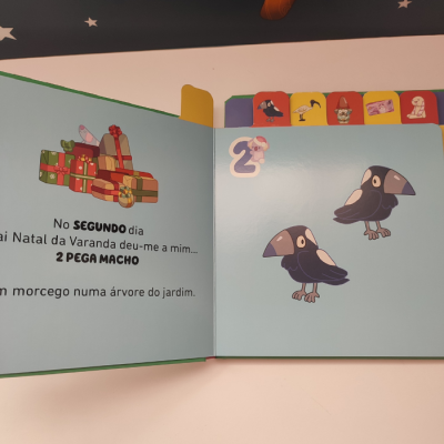 Página aberta de livro infantil com ilustrações de presentes e dois pássaros cartoon.