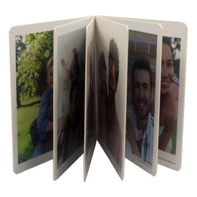 Álbum de fotografias coloridas com capa branca e várias páginas abertas