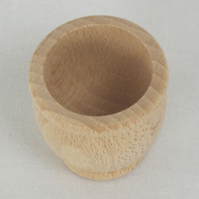 Copo pequeno de madeira natural claro, superfície lisa e textura de grão visível