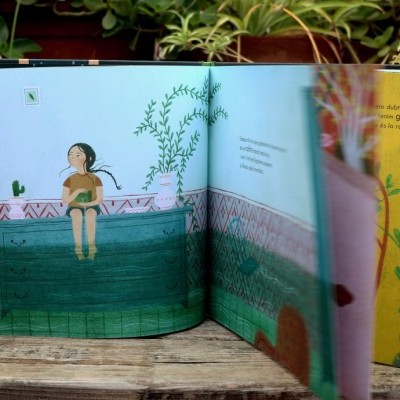 Livro infantil aberto com ilustrações coloridas de um menino numa piscina e paredes decoradas