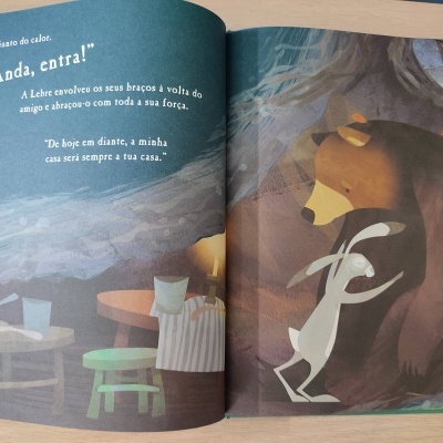 Livro infantil aberto mostrando um coelho abraçando um urso e texto em português