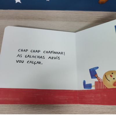 Página de livro infantil com texto e ilustração de criança a calçar galochas azuis