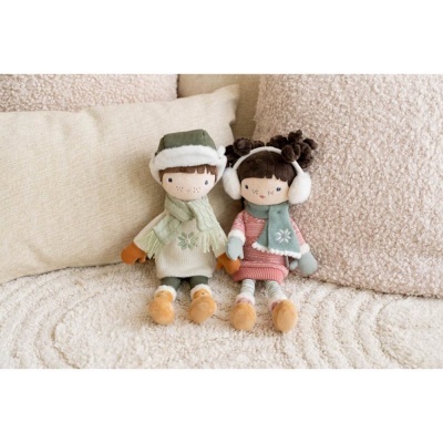 Dois bonecos de pelúcia com roupa de inverno sentados num sofá creme.