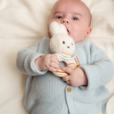 Bebé com conjunto de malha azul e peluche coelho branco às riscas