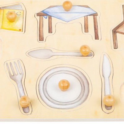 Puzzle de madeira com peças de cadeiras, mesa, talheres, prato, chávena e alimentos.