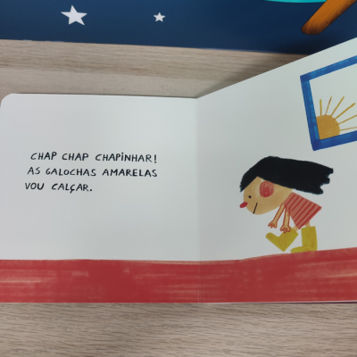 Página de livro infantil com criança a calçar galochas amarelas e texto em português
