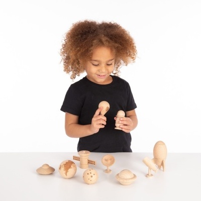 Criança brinca com brinquedos de madeira clara