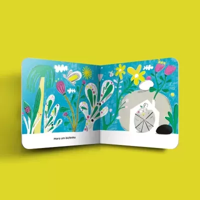 Livro infantil aberto com ilustrações de plantas coloridas e texto em português sobre fundo amarelo