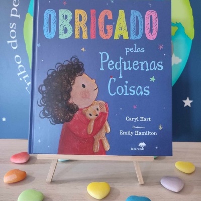 Livro infantil 'Obrigado pelas Pequenas Coisas' com capa azul e ilustração de criança com urso de peluche