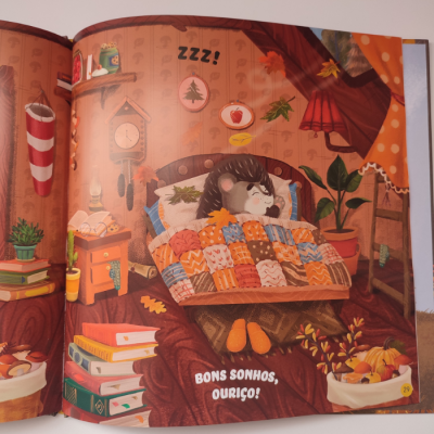 Ilustração de um ouriço a dormir numa cama com edredão colorido num quarto acolhedor com livros, plantas e decoração outonal