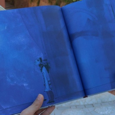 Livro aberto com fundo azul e texto numa página