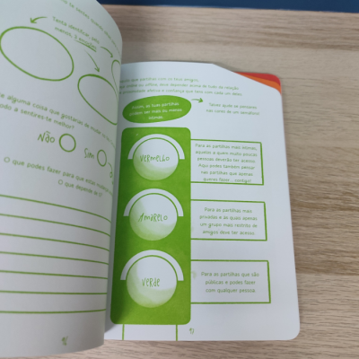 Livro aberto com texto e diagramas de semáforo em verde sobre superfície de madeira