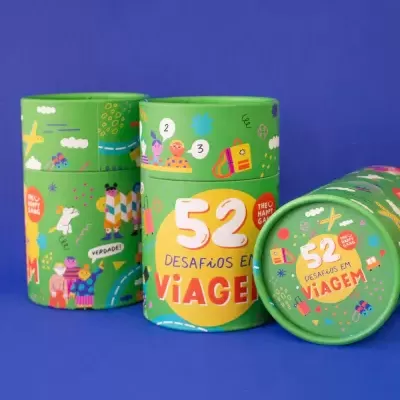 Embalagens cilíndricas verdes coloridas com o texto 52 DESAFIOS EM VIAGEM