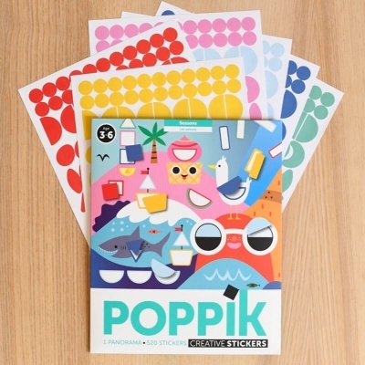 Livro de autocolantes Poppik com várias folhas de autocolantes coloridos sobre mesa
