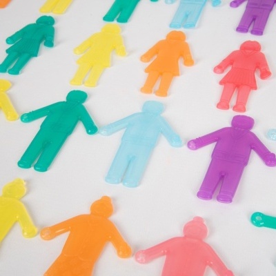 Figuras humanas coloridas de plástico translúcido em padrão de mãos dadas