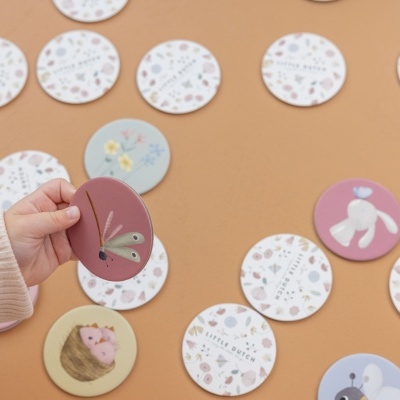 Jogo de memória com peças redondas ilustradas em fundo bege.