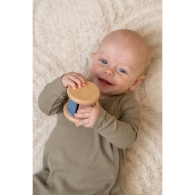 Bebé de pijama cinzento claro a segurar brinquedo de madeira com detalhe azul