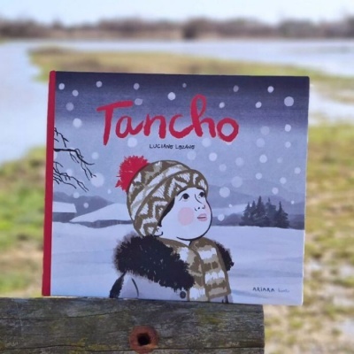 Capa de livro infantil 'Tancho' com ilustração de menino com gorro, cachecol e casaco em paisagem nevada