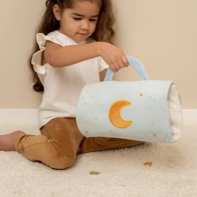 mochila infantil azul clara com lua e estrelas, criança sentada no chão