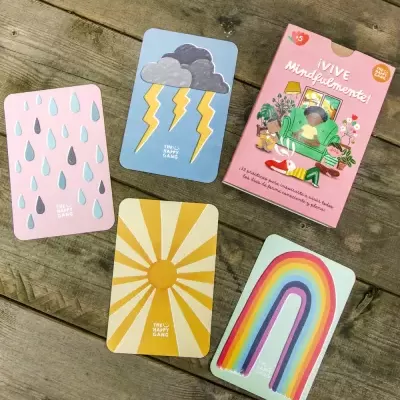 Cartas ilustradas com gotas, nuvens, sol e arco-íris e embalagem de Jogo VIVE Mindfulamente em madeira