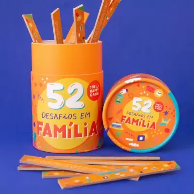 Embalagem laranja com texto 52 Desafios em Família com paus de madeira coloridos