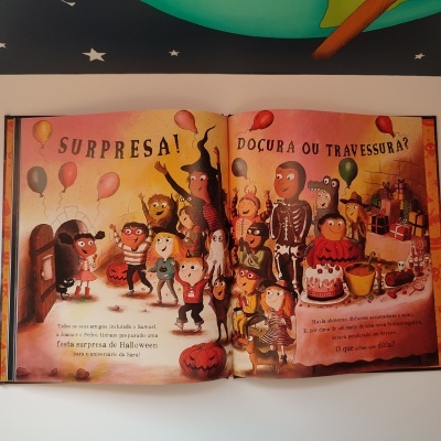 Páginas de livro infantil com ilustração de crianças fantasmas, balões e texto de Halloween em português.