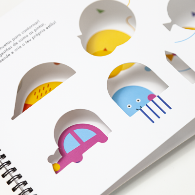 Livro espiral com recortes coloridos e texto em português