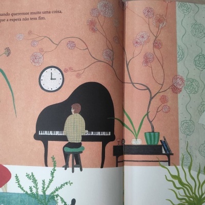 Cenário interior com piano, plantas, homem sentado ao piano, mulher a ler em poltrona vermelha.