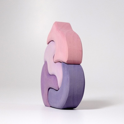 Três blocos de madeira entrelaçados em tons de roxo, lilás e rosa.