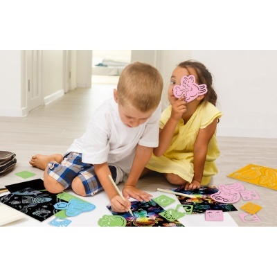 Crianças a brincar e pintar com recortes coloridos num chão de madeira claro