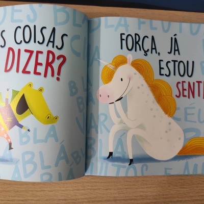 Livro aberto com ilustrações de crocodilo e cavalo, texto em português