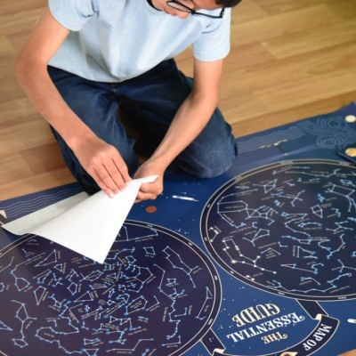 Mapa astronómico azul escuro com constelações em branco exibido no chão