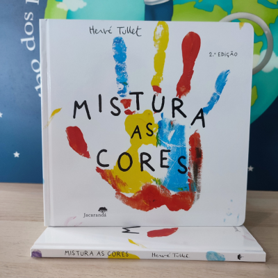 Capa de livro infantil branco com mão colorida e título Mistura as Cores
