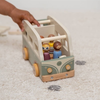 Carrinho de madeira com figuras humanas coloridas e rodas amarelas sobre tapete bege